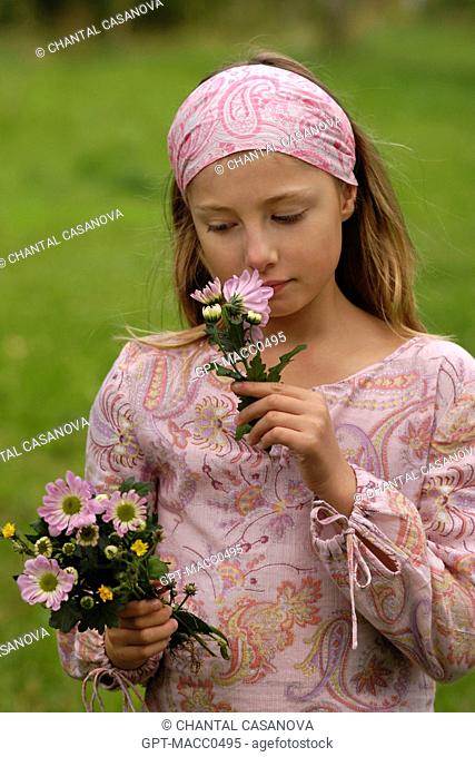 YOUNG TEN-YEAR-OLD GIRL PICKING FLOWERS IN THE COUNTRYSIDE