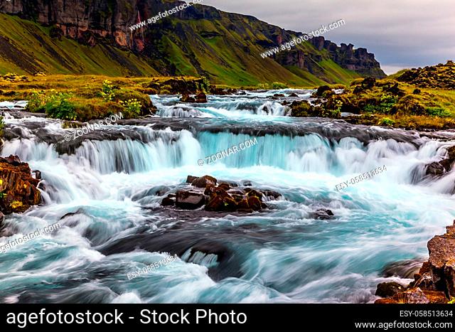 Powerful cascading waterfalls in Iceland. Main road around the island. Travel in July. Concept of active and extreme tourism