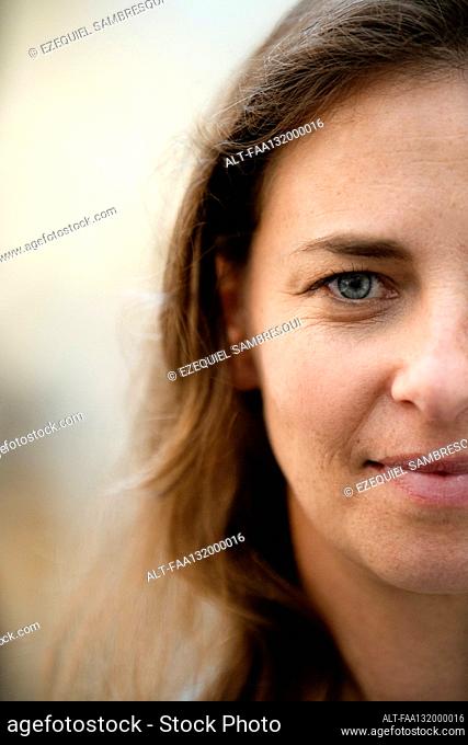 Portrait of half face of adult woman looking at camera