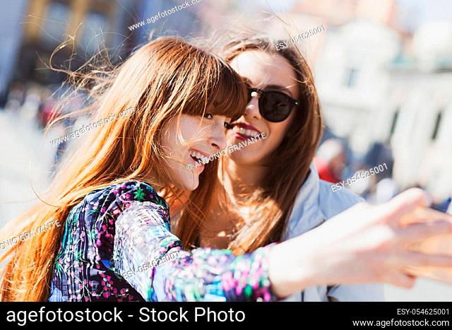 Two young adults take a selfie in Piazza del Plebiscito in Naples
