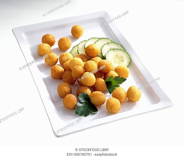 Deep-fried potato balls with sliced cucumber