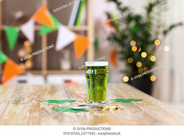 glass of green beer, horseshoe and golden coins