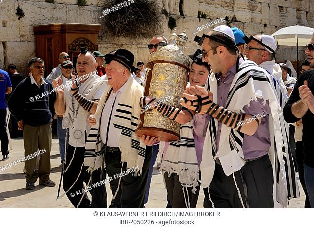 Bar Mitzvah celebration at the Western or Wailing Wall in the direction of the Jewish Quarter, boy is carrying the Torah scroll with the help of his father