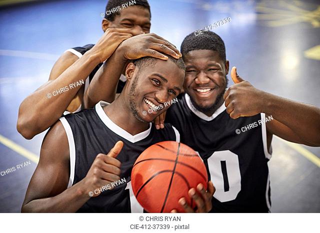 Portrait smiling, confident young male basketball player team celebrating, gesturing thumbs-up