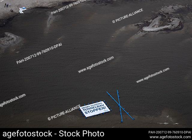 12 July 2020, Schleswig-Holstein, Fehmarn: Supporters and activists of the protest action ""Beltretter"" hold a banner with the text ""Protect Baltic Sea