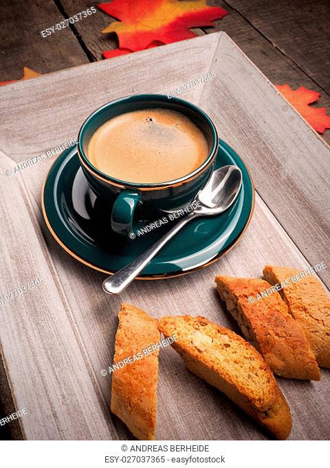 Delicious cup of espresso with cantuccini on a wooden plate