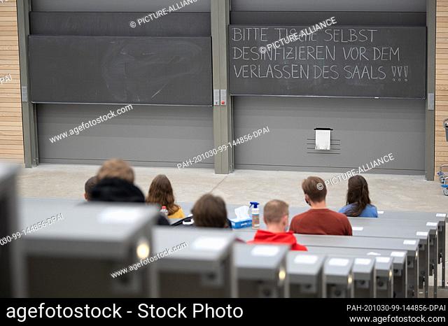 29 October 2020, Baden-Wuerttemberg, Stuttgart: Students wearing mouth and nose masks sit in front of a blackboard at the welcome event for first semester...