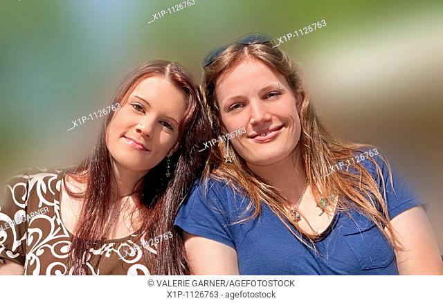 This stock photo are two young adult Caucasian brunette women both with long hair and smiling who are both sisters and friends They are in their early twenties...