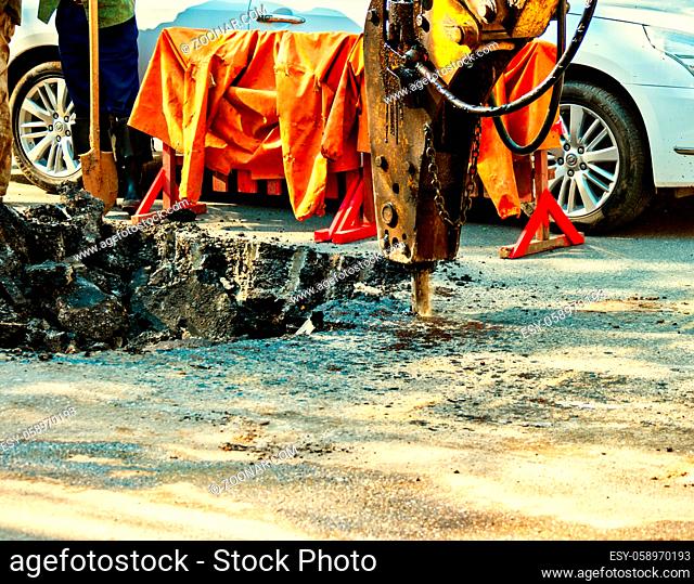 Construction machine destroy the asphalt surface of the road, repair work
