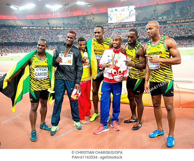 Jamaica's winning 4x100m relay Nesta Carter (L), Usain Bolt (C), Nickel Ashmeade (2nd R) and Astafa Powell (R) pose with the men's 5000m gold medalist Mohamed...