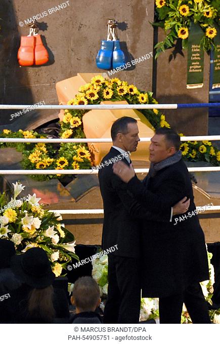Former boxing pros and world champions Dariusz Michalczewski (R) and Henry Maske embrace during the funeral service of late boxing coach Fritz Sdunek in Hamburg