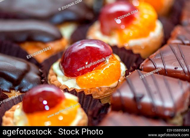 Close-up of a cupcake with cream and fruits. Grape and orange