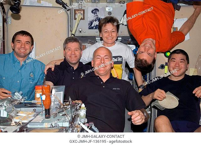 STS-122 and Expedition 16 crewmembers share a meal at the galley in the Zvezda Service Module of the International Space Station