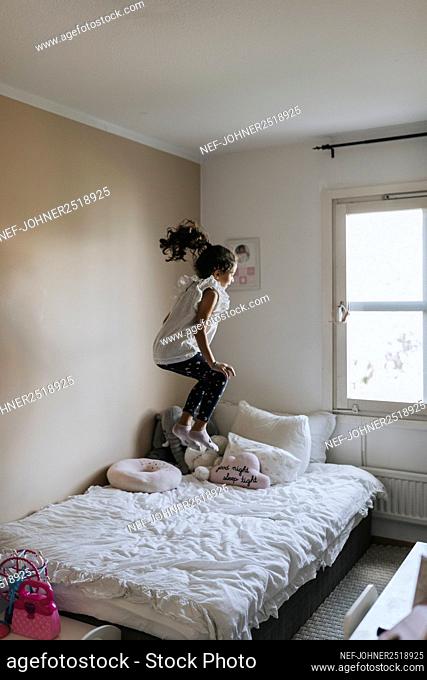 Girl jumping on bed