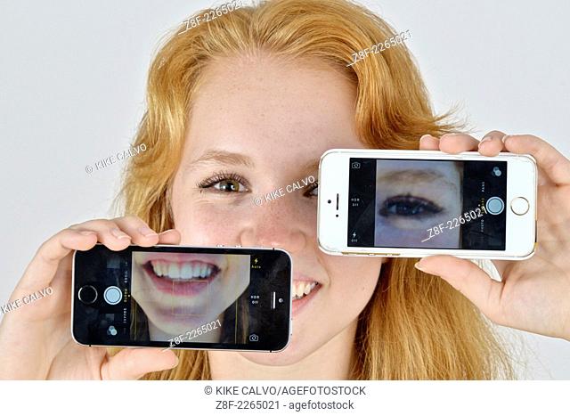 Portrait of an auburn teen taking a self portrait with a phone