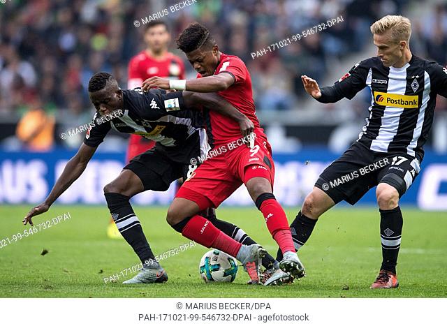 Leverkusen's Leon Bailey (C) and Gladbach's Denis Zakaria (L) and Oscar Wendt vie for the ball during the German Bundesliga soccer match between Borussia...