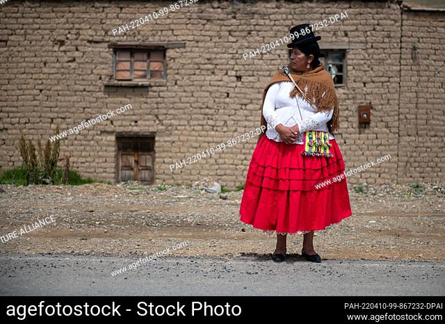 09 April 2022, Bolivia, Jankho Amaya: A woman, recognizable by her clothing as a local authority, watches a bicycle race