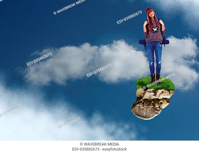 Hiking adventurer woman with rucksack on floating rock platform in sky