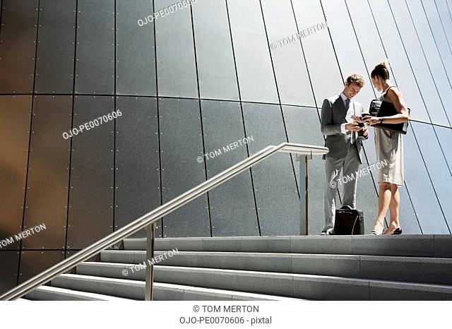 Business people talking at top of steps outdoors