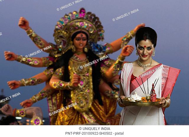 Woman holding a pooja thali at Durga puja festival