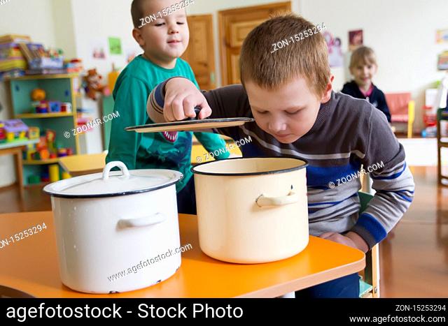Nutrition of children in preschool. The boy wants to eat. Look in the pan
