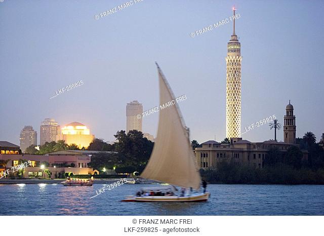 Feluka on the river Nile at dusk, Cairo Tower and opera house in the background, Cairo, Egypt, Africa
