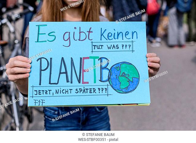 Girl holding a placard on a demonstration for environmentalism