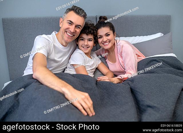 Happy family. A happy family in bed together looking peaceful
