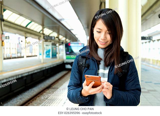 Womanuse of cellphone at train platform