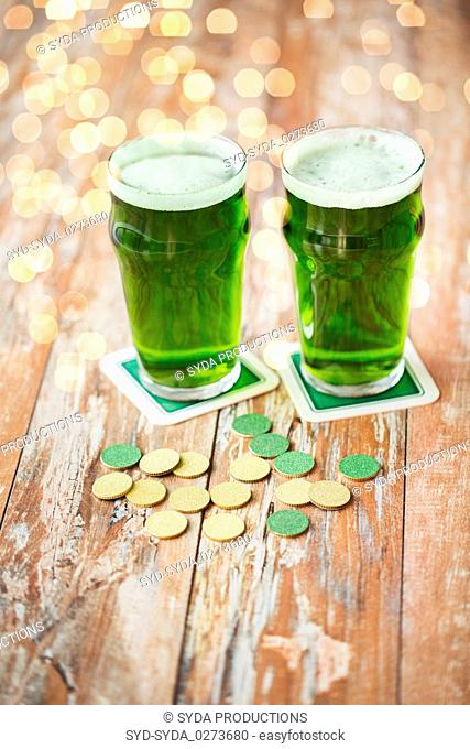 glasses of green beer and gold coins on table