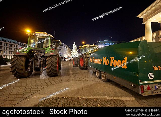17 December 2023, Berlin: Farmers from Ostholstein stand with their tractors in front of the Brandenburg Gate. Hundreds of farmers have made their way to Berlin...