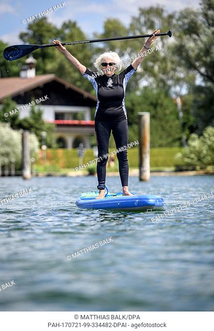 The 79-year-old Elisabeth Roesl lifts up her paddle while stand up paddling across the Starnberg River at the beach resort Starnberg, Germany, 13 July 2017