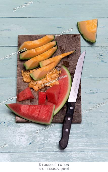 Slices of watermelon and cantaloupe melon on a wooden board