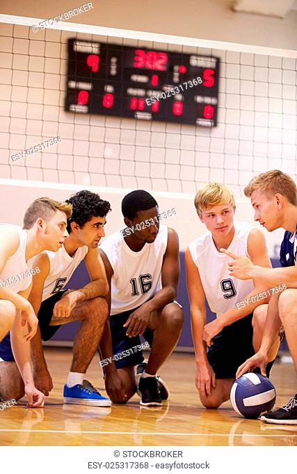 Male High School Volleyball Team Having Team Talk From Coach