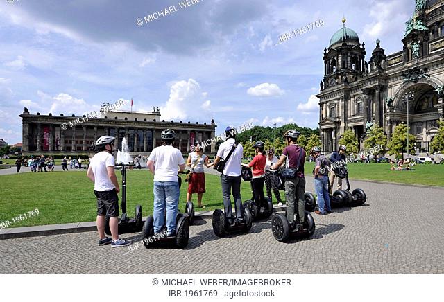 City tour for tourists riding Segways, in front of Berlin Cathedral, Supreme Parish and Collegiate Church in Berlin, and Altes Museum