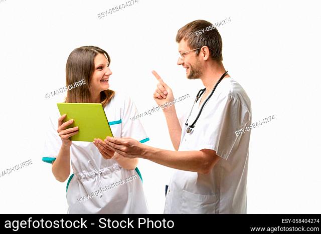 Two doctors have fun discussing information on a tablet