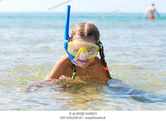 Six-year girl swims with a mask and snorkel under water at the seaside
