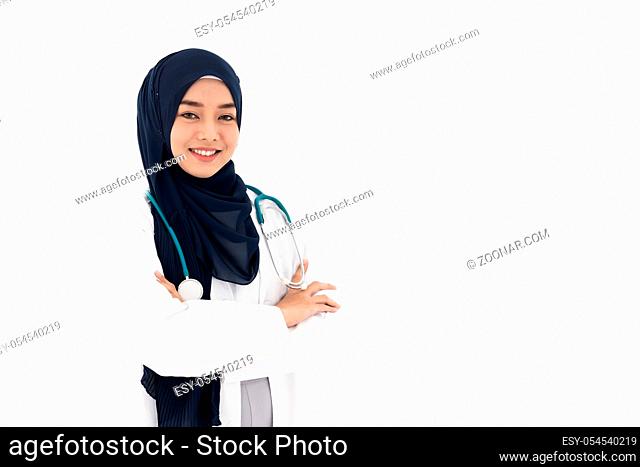 Portrait of Muslim confident female doctor medical professional sitting in examination room in hospital clinic. Positive face expression