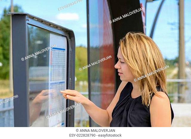 Woman looking a timetable in a station