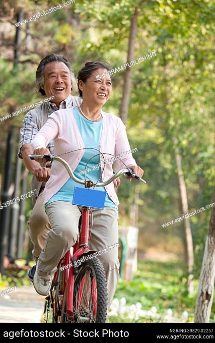 Older couple riding tandem bicycle, Beijing