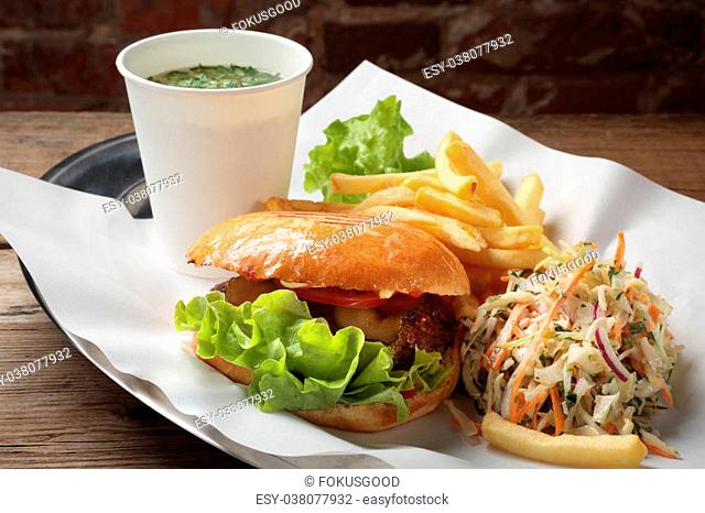 The food with soup, burger and salad on a tray with white paper