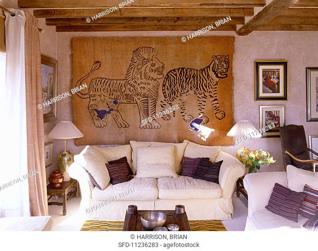 A bright living room in an English country house with a sofa and hand-knotted wall hanging from China
