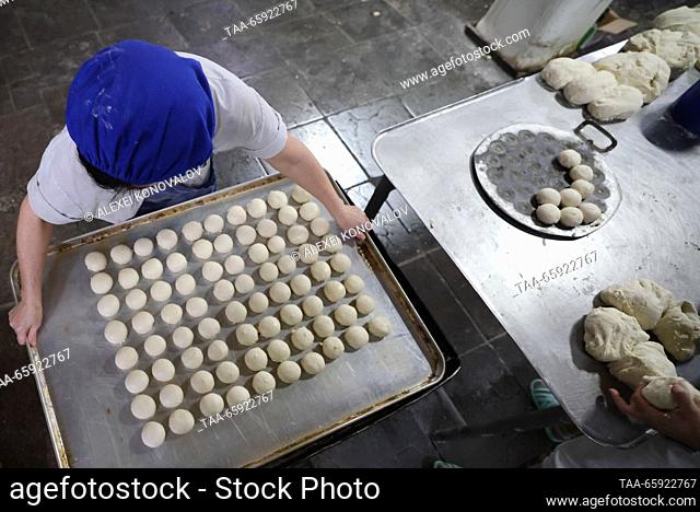RUSSIA, ZAPOROZHYE REGION - DECEMBER 19, 2023: An employee carries a tray at the Berdyansk Bakery in the city of Berdyansk