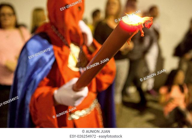 Bearer or nazareno holding large candle at Holy Week Procession, Spain