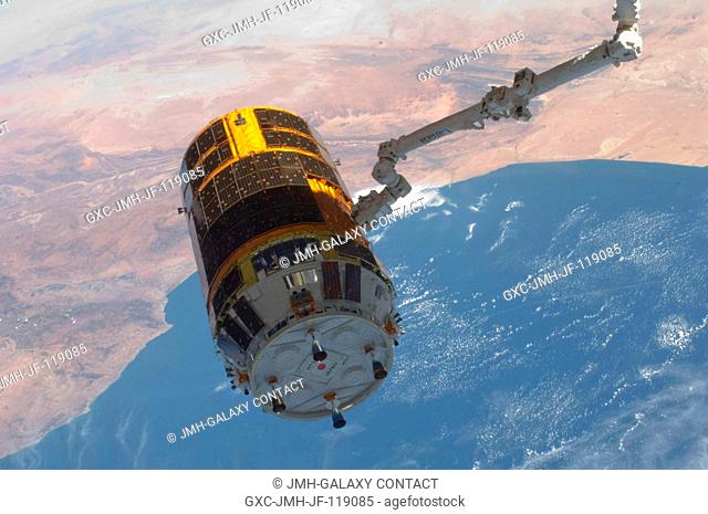 With an oblique view of the southwest coast of Morocco serving as a backdrop, the International Space Station's Canadarm2 grasps the unpiloted Japan Aerospace...