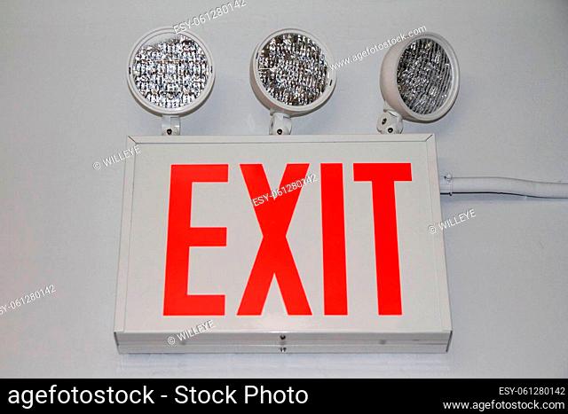 The flashing red security exit sign with three powerful lights on the exit of a building