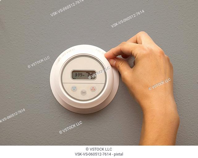 USA, Illinois, Metamora, close-up of woman adjusting thermostat