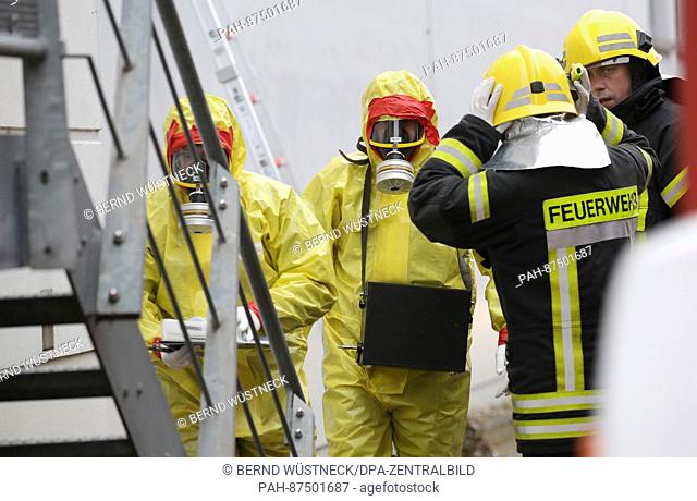 Firefighters wearing protective clothing can be seen after the discovery of a letter containing brown powder at the regional court in Neubrandenburg, Germany