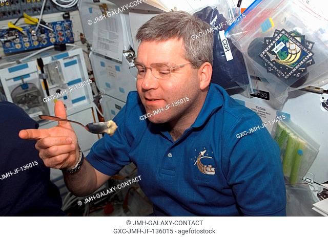 Astronaut Steve Frick, STS-122 commander, eats a snack on the middeck of Space Shuttle Atlantis