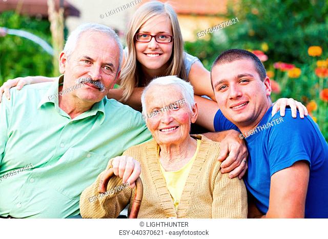 Generations in one image: grandmother, son and young grandchildren in the garden of the nursing home